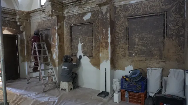 Los restauradores recuperan las pinturas que cubren las paredes de la ermita.