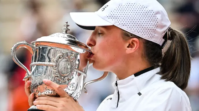Iga Swiatek besa la copa que la acredita como ganadora de Roland Garros 2023.