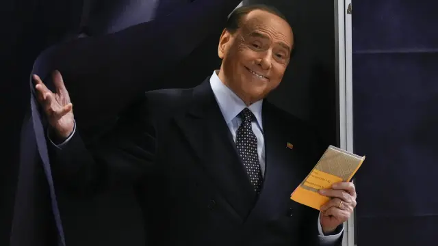 FILE - Silvio Berlusconi comes out of a voting booth before casting his ballot at a polling station in Milan, Italy, Sept. 25, 2022. Berlusconi, the boastful billionaire media mogul who was Italy's longest-serving premier despite scandals over his sex-fueled parties and allegations of corruption, died, according to Italian media. He was 86. (AP Photo/Antonio Calanni, File )