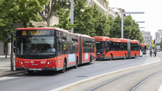 Varios autobuses a su paso por el paseo de la Independencia de Zaragoza, junto a la línea del tranvía.