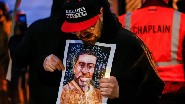 Un hombre sostiene una imagen de George Floyd en una vigilia en el segundo aniversario de la muerte de Floyd, que fue asesinado en 2020 por un policía de Mineápolis