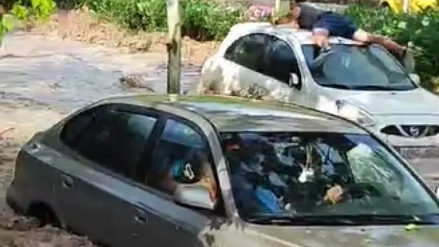Un conductor sobre un coche arrastrado por el agua en medio del Tercer Cinturón de Zaragoza
