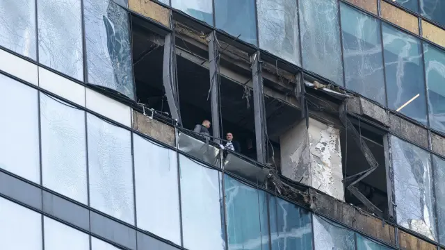 Dos policías moscovitas examinan los daños producidos por un dron en un edificio de la city de Moscú.
