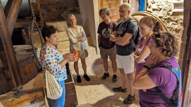 Serafina Buj descubre a un grupo de visitantes el molino de Miravete.