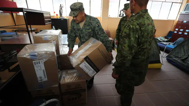 Militares distribuyen material electoral de cara a las elecciones presidenciales y legislativas extraordinarias de Ecuador, este sábado en Quito