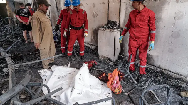 Miembros del equipo iraquí de rescate, en el establecimiento donde tuvo lugar el incendio.