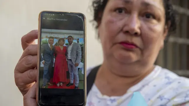 Miriam Montealegre, muestra una foto de sus sobrinos, Erick Torres y Sergio Silva junto a su madre Martha Hernánez, los tres desaparecidos en el incendio.