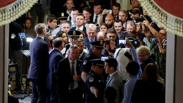 McCarthy, en el centro de la imagen, rodeado de periodistas y personal de seguridad a su salida de la Cámara Baja