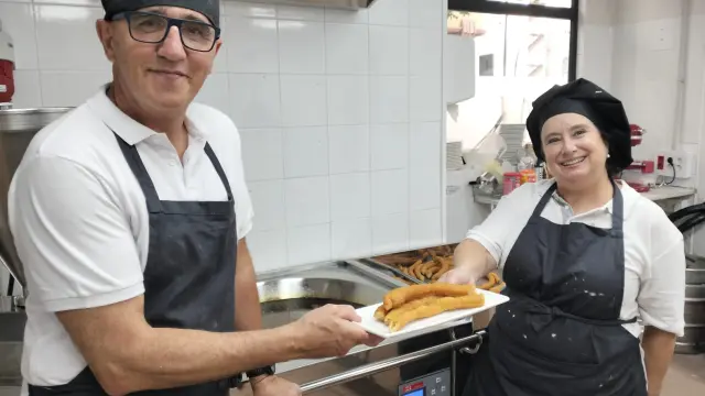 Fermín Moreno y una de sus empleadas muestran los churros tejeringos en la chocolatería Mmm, ¡qué rico!
