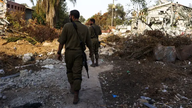 Be'eri (Israel), 17/10/2023.- Israeli soldiers walk near destroyed houses during a guided visit of the media to the destroyed Be'eri Kibbutz, Israel, 17th October 2023, which was attacked by Hamas on 07 October. Israel has warned all citizens of the Gaza Strip to move to the south ahead of an expected invasion. More than 3,000 Palestinians and 1,400 Israelis have been killed according to the Israel Defense Forces (IDF) and Palestinian Health Ministry, after Hamas militants launched an attack against Israel from the Gaza Strip on 07 October. (Kibutz) EFE/EPA/MANUEL DE ALMEIDA