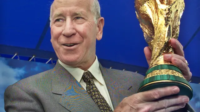 FILE PHOTO: FIFA Ambassador and England soccer legend Bobby Charlton holds up the FIFA World Cup trophy at a kick-off of the trophy's 10-city tour of Japan in Yokohama, venue of the World Cup final match, west of Tokyo March 9, 2002. The trophy is to tour Shizuoka, Osaka, Kobe, Oita, Saitama, Kashima, Niigata, Sendai, and Sapporo, after which it goes on tour in South Korea. REUTERS/Eriko Sugita ES/CP/File Photo