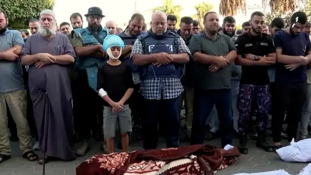 El periodista de Al Yazira Wael al Dahdouh, en el centro, durante el funeral por su esposa e hijos, fallecidos en un bombardeo israelí.