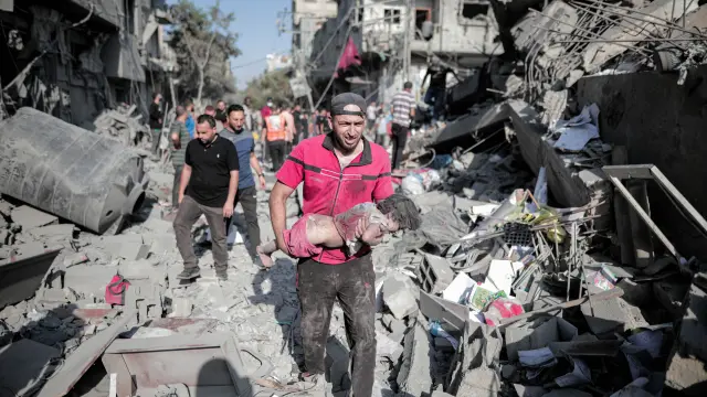 November 5, 2023: Deir Al-Balah, Gaza Strip, Palestine. 05 November 2023. A man carries a toddler amid the rubble following Israeli raids on the Al-Bureij refugee camp in the Deir Al-Balah governorate in central Gaza. Attacks on crowded residential areas in Gazas refugees camps have intensified in the latest few days, with the camps of Jabalia (in the northern Gaza Strip), Al-Shati, Al-Bureij, and Al-Maghazi (in central area of the Gaza Strip), being targeted in the ongoing Israeli military operation in the Gaza Strip,Image: 819979090, License: Rights-managed, Restrictions: , Model Release: no, Credit line: Adel Al Hwajre / Zuma Press / ContactoPhoto.Editorial licence valid only for Spain and 3 MONTHS from the date of the image, then delete it from your archive. For non-editorial and non-licensed use, please contact EUROPA PRESS...05/11/2023[[[EP]]]