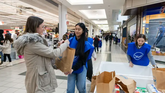 Una donante entrega una bolsa con productos a una voluntaria, este sábado en un Carrefour.