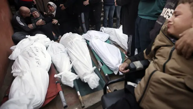 Palestinians mourn relatives killed in the Israeli bombardment of the Gaza Strip outside a morgue in Khan Younis on Sunday, Dec. 10, 2023. (AP Photo/Mohammed Dahman)