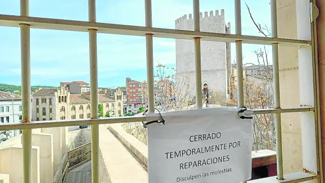 La torre de la Bombardera, al fondo, y en primer plano el cartel que avisa del cierre del acceso.