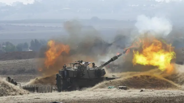 Flames erupt as an Israeli mobile artillery unit fires a shell from southern Israel towards the Gaza Strip, in a position a near the Israel Gaza border, Israel on Oct. 11, 2023. (AP Photo/Erik Marmor)