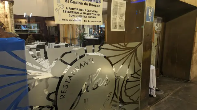 Cartel colocado hace unos días en la entrada del restaurante Flor de Huesca avisando del traslado.