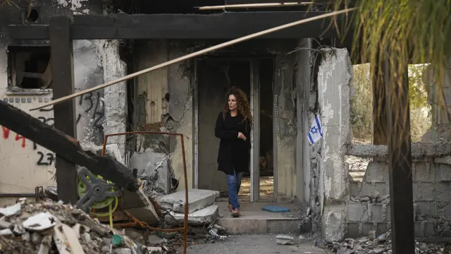Carmit Dvory, visits the ruins of a house belonging to members of her community in Kibbutz Be'eri, Israel, Wednesday, Dec. 20, 2023. The kibbutz was overrun by Hamas militants from the nearby Gaza Strip on Oct.7, when they killed and captured many Israelis. (AP Photo/Ohad Zwigenberg)