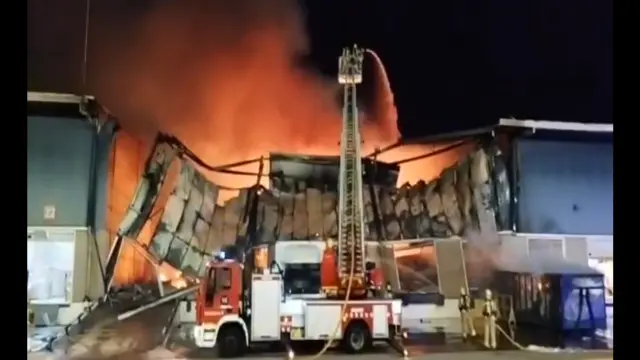 Los bomberos intentando apagar el fuego en el polígono industrial de Reus
