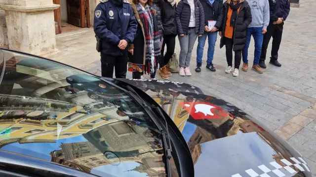 Representantes municipales, de la Policía Local y de seis asociaciones, posan ante la puerta del Ayuntamiento de Teruel.