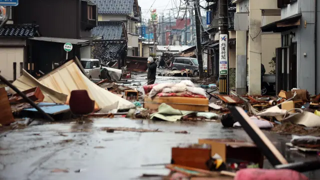 Un hombre, en una calle llena de restos de los edificios dañados a causa del terremoto en la ciudad japonesa de Suzu, en la prefectura de Ishikawa
