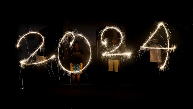Una imagen con velocidad de obturación lenta muestra a varios jóvenes formando ‘2024’ con pequeñas bengalas durante las celebraciones del Año Nuevo en Colombo, Sri Lanka.