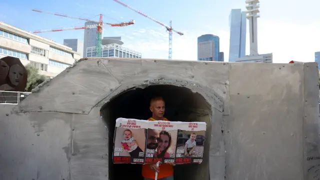 Un hombre muestra en Tel Aviv imágenes de sus familiares secuestrados por Hamas MIDEAST ISRAEL PALESTINIANS GAZA CONFLICT