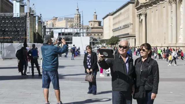 Varios turistas se fotografían delante de la basílica del Pilar.
