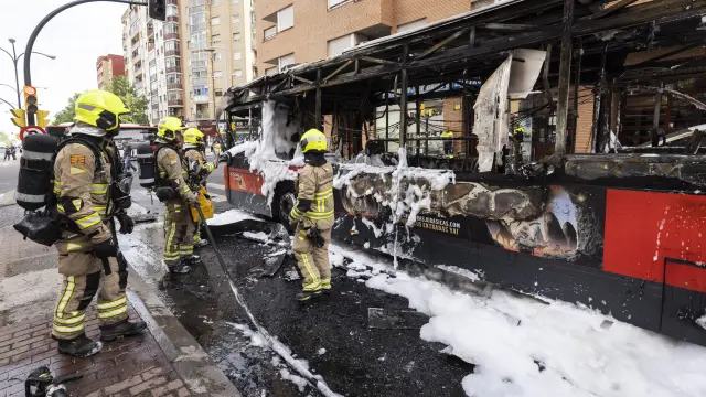 Varios bomberos sofocan el incendio de un bus urbano en abril del año pasado, en Tenor Fleta