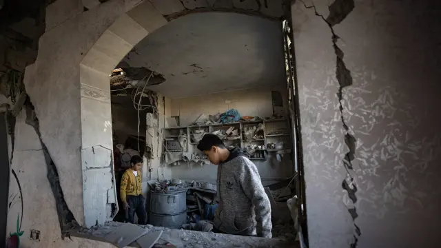 Decenas de palestinos inspeccionan los daños tras el último ataque en el campo de refugiado de Rafah.