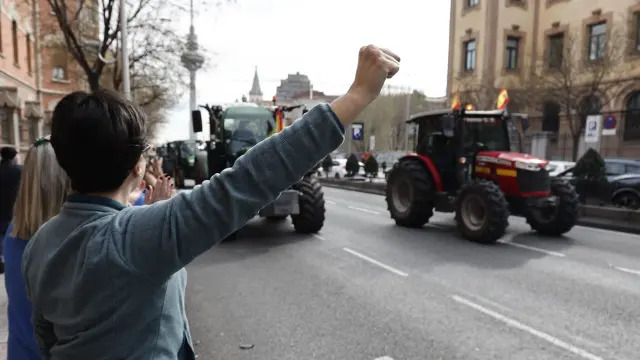 Varias personas saludan a los agricultores en la tractorada por la calle de O'Donnell en Madrid.