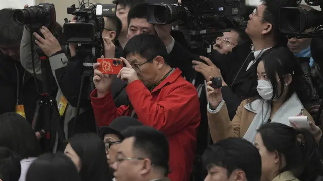 Journalists take pictures of National People's Congress spokesperson Lou Qinjian during a press conference on the eve of the National People's Congress at the Great Hall of the People in Beijing, Monday, March 4, 2024. (AP Photo/Tatan Syuflana)