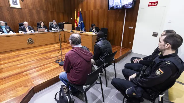 Yacouba K., a la derecha de su intérprete, durante el juicio por agresión sexual celebrado este jueves en la Audiencia de Zaragoza.