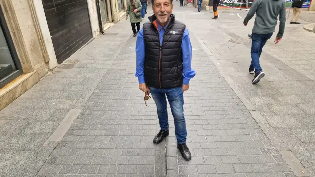 El poeta Jesús Cuesta posa junto a su verso escrito en la calle del Tozal
