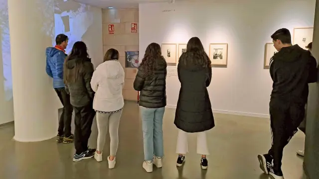 Público en la sala de exposiciones de la Diputación de Huesca viendo 'La lluvia amarilla'.