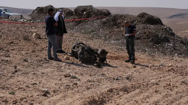 un policía inspecciona los restos de un misil lanzado por Irán que, según las autoridades israelíes, ha herido de gravedad a una niña de una comunidad beduina por impacto de metralla.