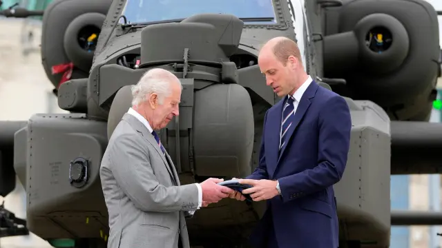El rey Carlos III entrega oficialmente el cargo de coronel jefe del cuerpo aéreo del Ejército al príncipe Guillermo frente a un helicóptero en el Centro de Aviación del Ejército en Middle Wallop, Reino Unido