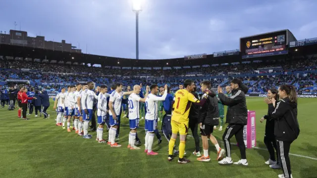 Los jugadores titulars del Real Zaragoza, en los saludos previos al partido frente al Racing de Ferrol.