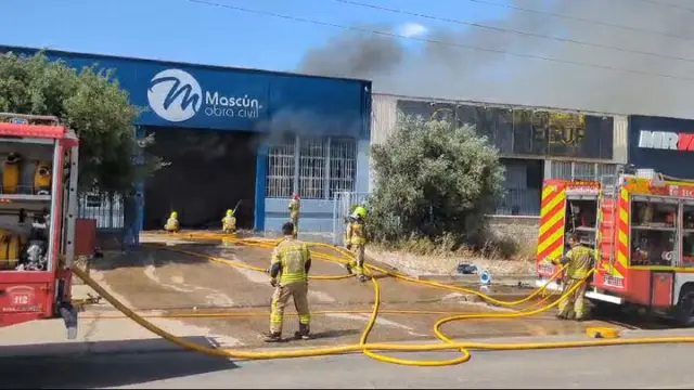 Varias dotaciones de bomberos trabajaabn en la extinción de un virulento incendio que ha destruido dos naves en el polígono Monzú de Huesca, una de ellas de residuos y otra de construcción.
