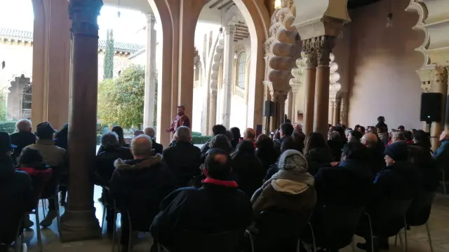 En el patio del Palacio, los recreadores explican a un público muy atento y abrigado en qué consiste la preparación pública