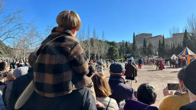 “¡Quiero ver la pelea!”, le grita Marco, de tres años y medio, a su padre, cuando este intenta darse la vuelta. Han venido en familia desde Zuera para asistir a los actos de la Coronación. “Nos quedaremos a comer por aquí y por la tarde a ver el cortejo, que nos han explicado por dónde irá e intentaremos seguirlo. El tema de los caballeros le encanta, y ahora verlo en directo, pues cuenta. Está emocionado”, subraya, acompañado de su mujer y su bebé de siete meses.