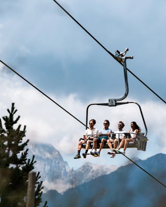 Cuatro excursionistas en el telesilla El Molino de Cerler, que sube hasta 2000 metros de altitud y que permite además portar bicicletas.