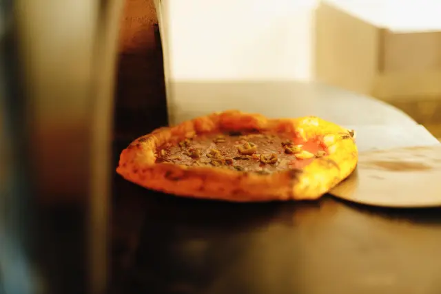 Una pizza napolitana recién sacada del horno de La Parthénope.