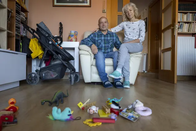 El matrimonio María Pilar Marqués y Juan Carlos Simón en su casa de Zaragoza con los juguetes del bebé al que acogen.