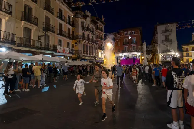 Varios asistentes corren en la traca de inicio de las fiestas de Teruel.