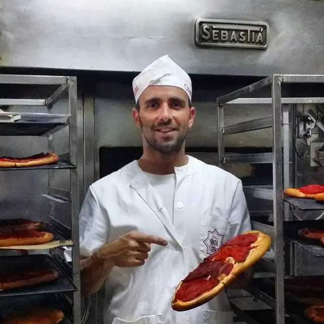 Javier Garzarán, cuarta generación de panaderos, posa con un regañao, en el Horno de Santa Cristina.