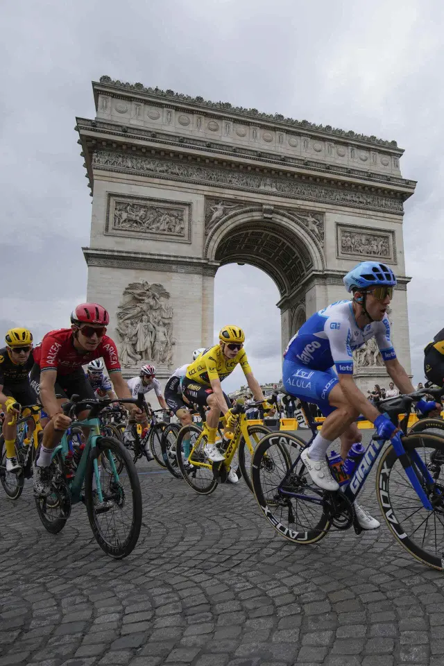 El maillot amarillo del Tour de Francia, el ciclista danés Jonas Vingegaard, pasa con el pelotón delante del Arco del Triunfo en París