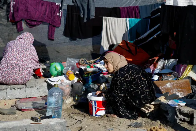 Una mujer observa cómo los palestinos desplazados, que huyeron de sus hogares debido a los ataques israelíes, se refugian en un campamento de tiendas de campaña