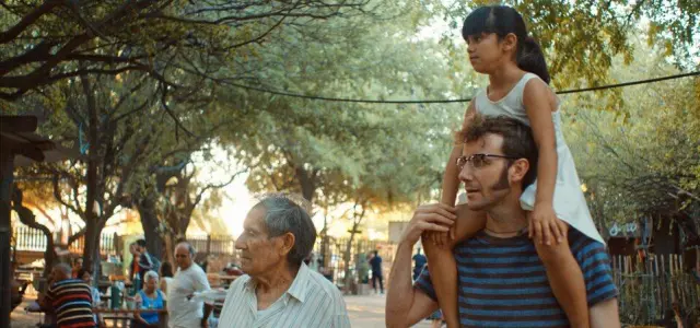 Uno de los fotogramas de la película: Mauricio (Pepe Lorente) descubre la música de Santiago del Estero y a esa niña que lleva sobre los hombros, a la que le deja tocar su guitarra.